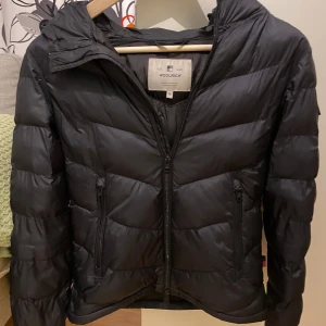 Svart jacka från Woolrich XS - Säljer en snygg svart jacka från Woolrich i mycket bra skick. Jackan har en dragkedja framtill och två praktiska fickor med dragkedja. Perfekt för kyliga höst- och vinterdagar. Den är långärmad och har en stilren design som passar till det mesta. Jackan har ett Woolrich märke på vänster arm också. Den sitter bra på mig som är 170 så skulle säg att den passar mellan 165-170. Mvh Hannes