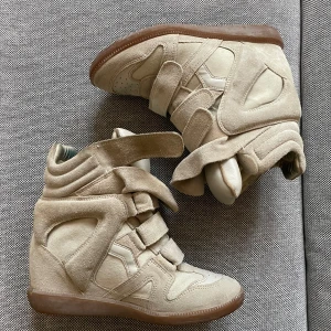 Beige sneakers från Isabel Marant - Säljer nu mina bekett sneakers då de ej kommer till användning längre och har ett annat par! Storlek 37, någon missfärgning inuti men inget som syns utanpå. Nästintill nyskick! Nypris 6000