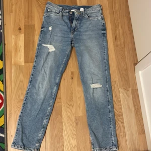 Blå slim fit jeans från H&M - Säljer ett par blå slim fit jeans från H&M i storlek 158. De har en justerbar midja och slitna detaljer för en cool look. Perfekta för vardagsbruk och passar till det mesta. Sköna och stiliga jeans som är ett måste i garderoben! 💙