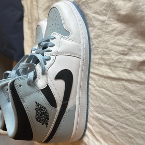 Nike Air Jordan i svart och ljusblått - Säljer ett par Jordan 1 mid ice blue. Aldrig använda. Säljs för över 2 tusen på svenska resellers men jag följer stockx:s priser. 1450kr