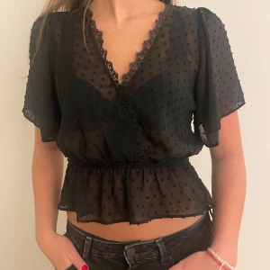 Svartprickig blus - Jättefin svart och lite halvgenomskinlig blus. Passar perfekt till fest och middag. Denna har jag haft som favorit länge! Jättebra skick!