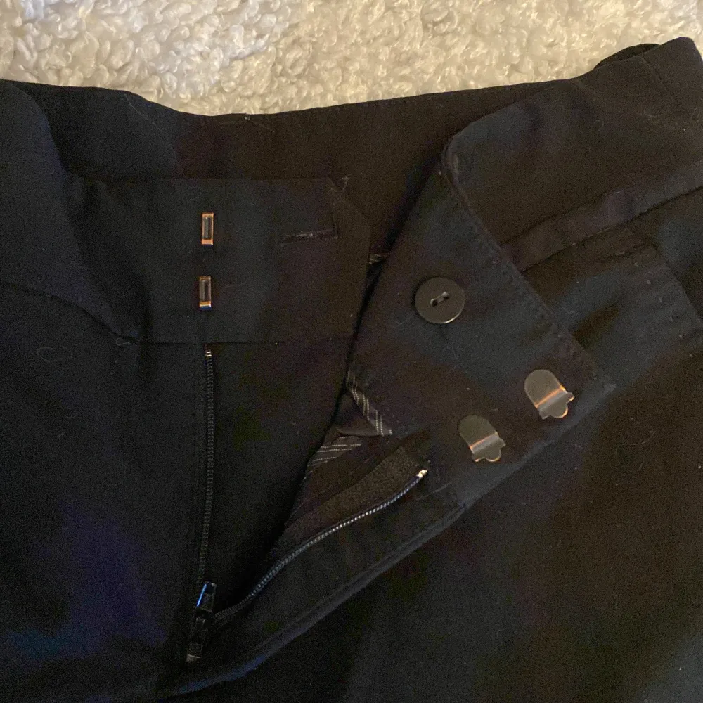 Säljer ett par stilrena kostymbyxor från Åhléns i märket InWear i storlek EUR 36. De har en straight passform och midwaist. Byxorna är i mycket bra skick förutom mindre slitage längst ner på byxorna. Perfekta för höst och vinter! Nypris: 1 200kr. Skriv privat vid frågor🩷. Farkut & Housut.