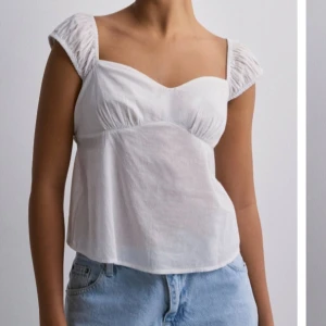 Vit blus med puffärmar - Säljer en söt vit blus med puffärmar och fyrkantig urringning. Perfekt för sommardagar eller en avslappnad vårlook. Blusen har en luftig passform och är gjord i ett lätt material som känns skönt mot huden.