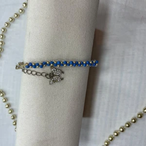 Blått och silverfärgat armband fjärilsdetalj - Snyggt armband i blått och silver med en glittrig fjärilsdetalj. Perfekt för att lägga till lite bling till din outfit. Armbandet har en justerbar kedja för att passa olika storlekar. Passar både till vardags och festliga tillfällen.