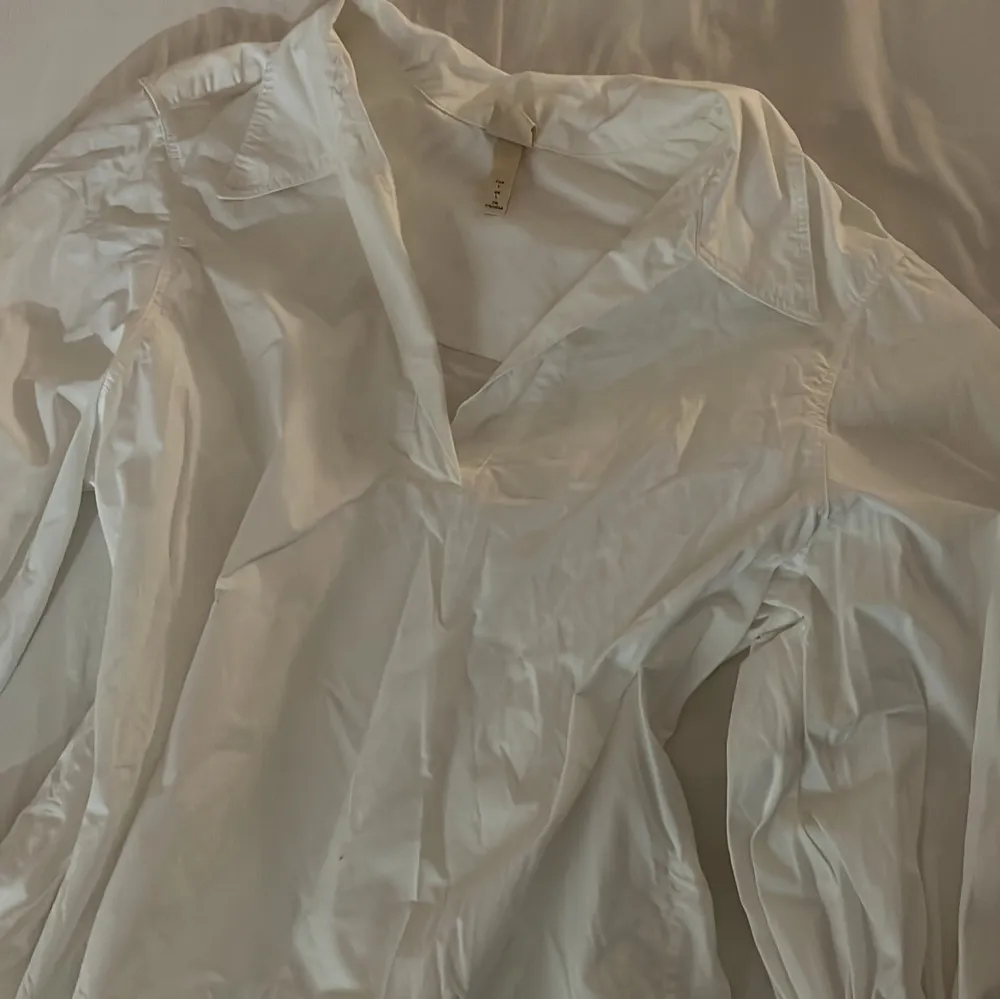 Säljer en stilren vit blus från H&M i storlek EU 38. Blusen har långa ärmar och en klassisk krage, perfekt för både vardag och fest. Materialet är lätt och bekvämt, vilket gör den idealisk för vår och sommar. Passar bra till både jeans och kjol!. Paidat.