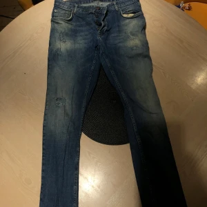 Blå jeans från Solid - LÄGG GÄRNA BUD!!! Säljer ett par snygga blå jeans från Solid i storlek 34/32. De har en klassisk straight fit och är i bra skick med en cool, sliten look. Perfekta för vardagsbruk eller en avslappnad utekväll. Passar bra till både t-shirt och skjorta!