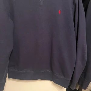 Mörkblå tröja från Polo Ralph Lauren - Säljer en snygg mörkblå tröja från Polo Ralph Lauren. Den har en klassisk design med det ikoniska röda logotypbroderiet på bröstet. Perfekt för både vardag och lite finare tillfällen. Tröjan är i bra skick. Sitter som en XS. Hör av er vid ytterligare frågor!