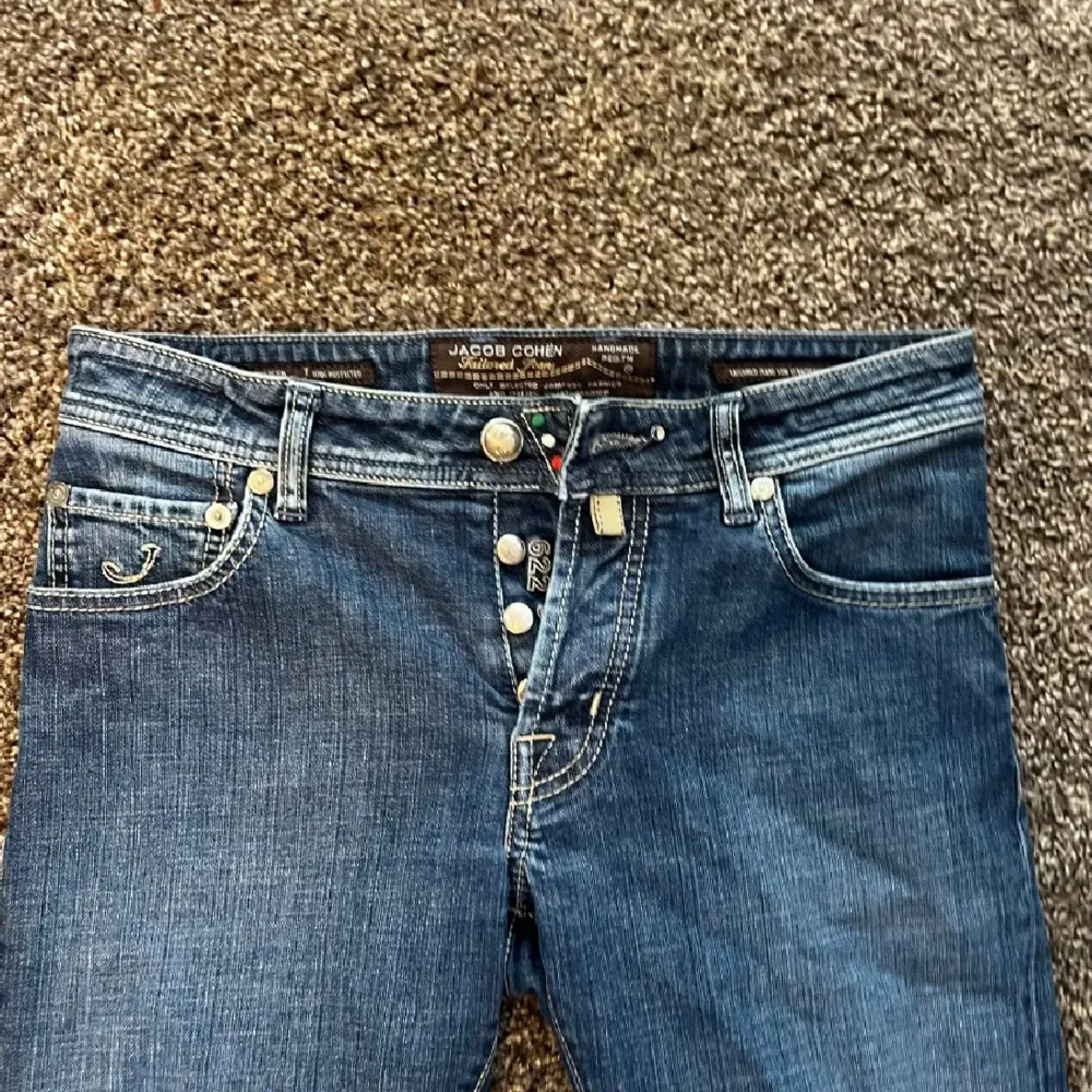 Säljer ett par snygga blå jeans från Jacob Cohen. De är i storlek 31 och passar någon som är mellan 170-176. Vid frågor eller funderingar är de bara att höra av sig!. Jeans & Byxor.