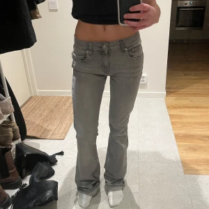 Grå jeans lågmidjade med bootcut - Säljer ett par snygga grå jeans från lager 157. De är lågmidjade och bootcut. Endast använda typ en gång, så inga defekter. Är 162 som ref och de är väldigt långa 