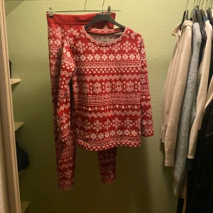 Jultröja med snöflingor - Mysig röd jultröja och byxor med vita snöflingor och geometriska mönster. Perfekt för vintern och julfirandet! Tröjan har långa ärmar och är gjord i ett bekvämt material. I storlek M och har aldig använt. I nyskick. 