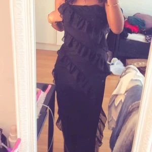 Tajt svart klänning med volanger - Säljer denna klänning då den inte kommer till användning. Den är svart, lång, tajt och har volanger nedför klänningen. Även stretchig så passar många storlekar och extremt bekväm. Köpt här på plick.💗(lånade bilder) pris går att diskutera 