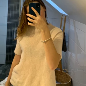 Beige kortärmad tröja - Säljer en supermjuk ljus rosa cashmir tröja med korta ärmar. Perfekt för både vår och sommar! Den har en enkel och klassisk design som passar till det mesta. På grund av en lite tvätt- miss har den krympt från storlek L till cirka S. Det är däremot inget som märks på tyget (det är inte stumt/stelt eller obekvämt - utan precis som tidigare). Förutom det är tröjan i bra skick.  Perfekt för en avslappnad look eller att klä upp med accessoarer.