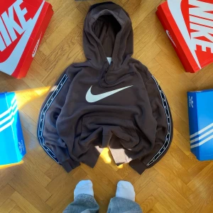 Brun hoodie från Nike - Säljer en snygg brun hoodie från Nike i storlek M. Den har en stor vit Nike-logga på framsidan. Väldigt bra skick, inga hål eller fläckar! Skriv om du har några frågor eller liknade!😊