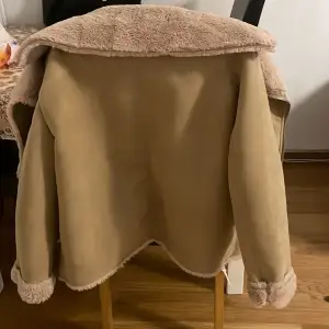 Säljer en supermysig beige teddyjacka från H&M. Den har en fluffig krage och muddar, samt en dragkedja framtill. Perfekt för kyliga höst- och vinterdagar. Jackan är i storlek M och är i nyskick. Passar både till vardags och fest! Inte använd!!