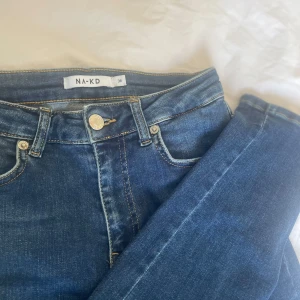 Nakd skinny high waist jeans - Mjuka skinny high waist jeans från Nakd. Säljs pga att de inte används men köpt secondhand & därav är det slitet på båda sidorna i hällorna i midjan. Även lite slitet på höger baksida lår.