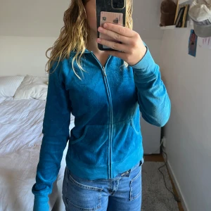 Blå hoodie från Juicy Couture - Säljer en superfin blå hoodie från Juicy Couture! Materialet är lite urtvättat som man ser på andra bilden och det saknas några stenar, annars helt perfekt. Storlek är M men den passar absoult S med! Säljer billigt den är köpt här💙