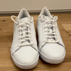 Vita sneakers - Vita sneakers Puma SMASH strl 40. Endast använda en gång, så mycket bra skick.  Säljer då de är för stora för mig. Nypris 600kr.