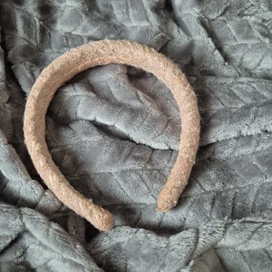 Beige diadem med glittrig yta - Snyggt beige diadem med en glittrig yta som ger en elegant touch. Perfekt för att lyfta din look med lite extra glamour. Diademet har en mjuk och bekväm passform.