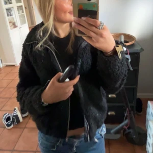 Svart teddyjacka - Mysig svart teddyjacka med dragkedja framtill. Perfekt för kyligare dagar och ger en trendig look. Jackan har en normal passform och långa ärmar.i storlek 152 men den passar mej och jag har XS-S i storlek