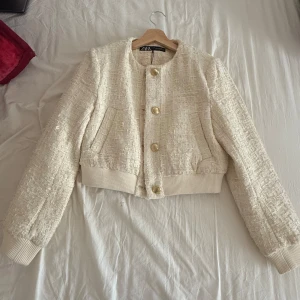  jacka från ZARA - Snygg beige jacka från ZARA med en texturerad yta och stora knappar framtill. Aldrig andvänt och prislappen finns kvar. Säljer den pga jag glömmde lämna tillbaka den och öppetköp var redan slut. Den är jätte fin och passar i vinter och sommar eftersom insidan kan ge värme och kall känsla. Elegant och fin!