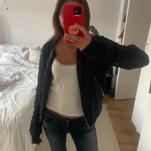 Marinblå bomberjacka från Topshop - Säljer en snygg marinblå bomberjacka från Topshop. Jackan har dragkedja framtill och flera praktiska fickor med dragkedjor. Perfekt för en cool och avslappnad stil. 🖤