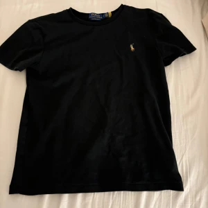 Svart t-shirt från Polo Ralph Lauren - En väldigt stilig Polo ralph lauren t-shirt. Den är äkta få jag köpte den ifrån zalando och den är även oanvänd. Säljer för att den inte passar längre. Skriv om ni har några funderingar 🩷