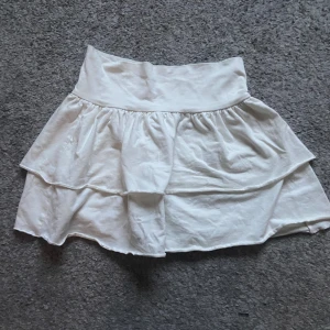 Vit kjol med volang - Supersöt vit volangkjol ifrån hm! Passar perfekt till en stickad tröja på våren eller en topp på sommaren! 