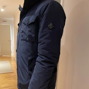 Mörkblå field jacket J.Lindeberg - Fet field jacket från j Lindeberg. Storlek L passar dig som bär M. Nyskick med inga defekter. Hör av dig om du har frågor.