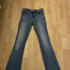 Blå slit flare jeans - Snygga blå slit flare jeans från märket C. De har en klassisk femficksdesign och en knappgylf. Perfekta för en avslappnad stil med en modern touch.