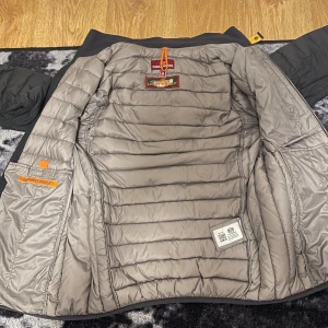 Para jumper jacka - Säljer en snygg och skön Parajumpers jacka med luva och dragkedja. Jackan har en quiltad design och är perfekt för kyligare väder. Den har praktiska fickor med dragkedjor och en märkestagg på ärmen. Den är M men funkar också som S. Jackan är i jätte bra skick och knappt använd. Tveka ej på att fråga frågor👍🏽