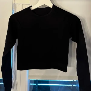 Svart träningströja  - Snygg svart croppad och ribbad träningströja. Från Gekås i storlek S