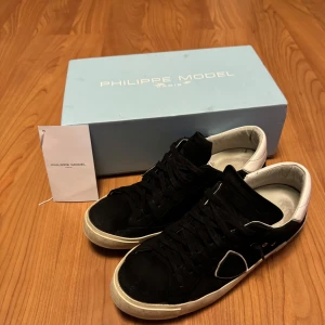 Philippe Model EU43 - Snygga svarta sneakers från Philippe Model i nubuck med vita detaljer. Skorna har en klassisk design med snörning och en bekväm sula. Storlek EU 43, allt i bilden ingår. Pris går att diskutera vid snabb och affär.