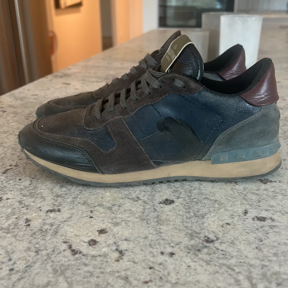 Blåa valentino rockrunners med vin-röd häl. De är använda med lätt slitning på höger tå. Men i övrigt väldigt fint skick och väldigt lite slitage. Box och kvitto medföljer. Storlek 41 men funkar lika bra på människor med storlek 42!. Skor.