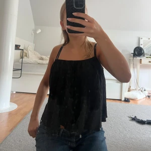 Svart ärmlös topp - Säljer en svart ärmlös topp med en luftig och bekväm passform. Perfekt för sommardagar eller en avslappnad kväll. Toppen har en enkel design med tunna axelband och är i Linné. säljer den då den tyvärr blivit för liten för mig, men är fortfarande i bra skick!
