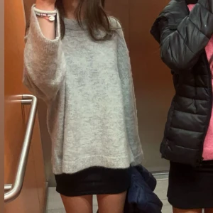 Grå stickad tröja från Gina  - Mysig grå stickad tröja med långa ärmar och en avslappnad passform. Perfekt för kyligare dagar och enkel att matcha med olika outfits.