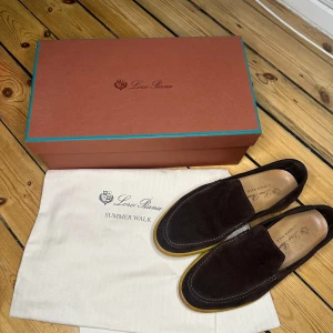 Loro Piana Summer Walk Loafers - Snygga bruna loafers i mocka från Loro Piana. Perfekta för en stilren och avslappnad look. Skorna kommer med originalkartong och påse. Detta är Summer Walk versionen och är välldigt svåra att få tag på.