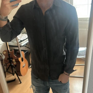 Burberry skjorta - Snygg mörkgrå skjorta med knappar och långa ärmar. Skjortan har ett diskret rutmönster och är perfekt för en stilren look. Den är tillverkad i ett mjukt material som ger en bekväm passform.