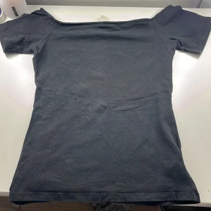 Svart offshoulder topp från H&M - Säljer en stilren svart offshoulder topp från H&M Basic-kollektionen. I storlek S.