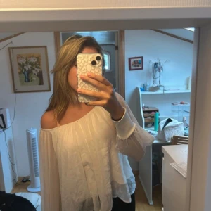 Vit offshoulder blus - Säljer en luftig och elegant vit offshoulder blus med långa ärmar. 