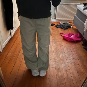 Parachutebyxor - Säljer ett par bekväma parachutebyxor från H&M. Byxorna har en loose passform med elastisk midja och dragsko för justerbarhet och två fickor där bak. Perfekta för en avslappnad stil. Har använts men inga defekter.