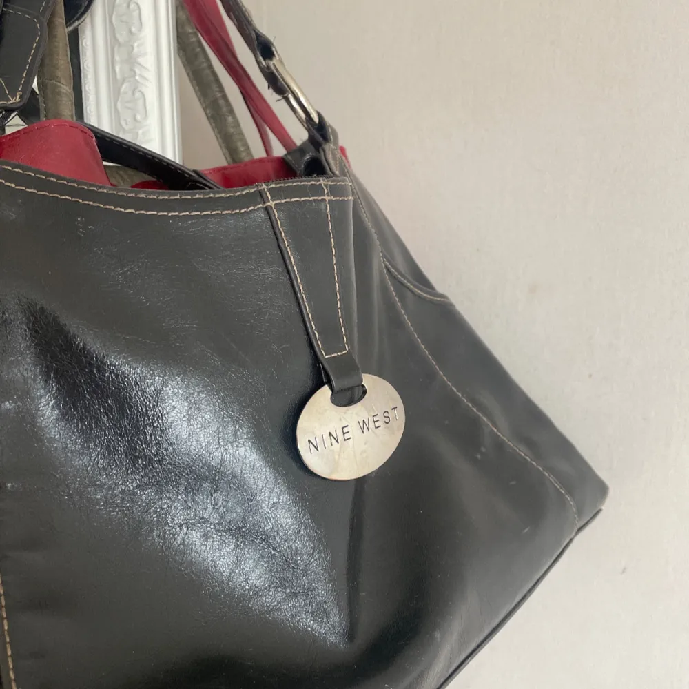 Svart handväska i äkta läder med silverdetaljer🩶HÖJD: 23 cm. BREDD: 42 cm. DJUP: 10 cm. REMDROPP: 24.5 cm. Befintligt skick, skick visas i bilderna! . Laukut & Käsilaukut.