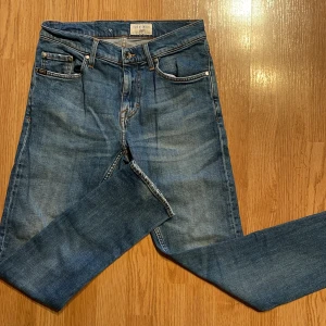Blå jeans från Tiger of Sweden - Snygga blå jeans från Tiger of Sweden med klassisk femficksdesign och dragkedja. Perfekta för en stilren look. Märkeslappen syns tydligt på insidan. Storlek 27/30