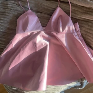 Rosa axelband topp - Säljer en söt rosa topp med smala axelband. Perfekt för sommarens fester eller en dag ute i solen. Toppen har en enkel och stilren design som gör den lätt att matcha med olika accessoarer. Använd gärna köp nu💞💞🥰