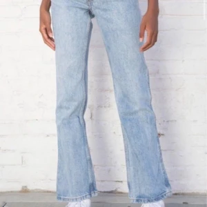 Ljusblå bootcut jeans, quinn jeans - Snygga ljusblå bootcut jeans i klassisk denimstil från brandy melville. De har en mid midja och en bekväm passform som ger en retro känsla. Perfekta för en avslappnad look.