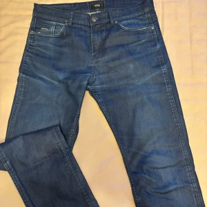 Blå jeans från Hugo Boss - Snygga blå jeans från Boss med stretchmaterial för extra komfort. Klassisk femficksdesign med knapp och dragkedja framtill. Perfekta för en stilren look.