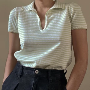 Vintage Henri Bende Knit Cotton Polo - Vintage Henri Bendel short sleeve polo knit top in a muted green & white stripe. Cotton Collared Top with a Ribbed Cuff and Hem. Best worn Fitted. Original Tag Size M. Model is 160cm (5”3) and generally fits S/M. Excellent condition. Made in Italy.  55 CM/ 21.7 IN Length 18 CM/ 7.1 IN Sleeve 33 CM/ 13 IN Shoulders 80 CM/ 31.5 IN Chest 68 CM/ 26.8 IN Waist  100% Cotton