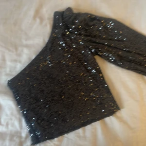 Svart glittrig topp från Bik Bok - Säljer en svart glittrig topp från Bik Bok i storlek XS. Toppen är täckt med paljetter som ger en festlig look. Perfekt för en utekväll eller speciella tillfällen. ✨
