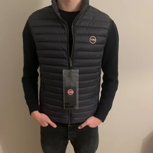 Colmar väst - Säljer en HELT NY väst från Colmar med alla tags kvar. Perfekt nu inför våren. Färg: Marinblå. Storlek: 50 (vilket motsvarar M). Vårt pris: 1199kr, nypris: 2499kr. Hör av er för fler bilder eller vid funderingar!