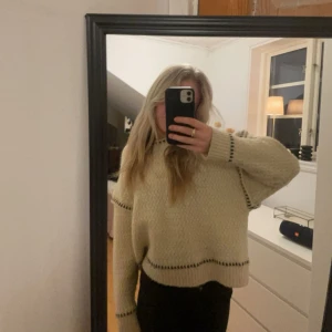 Beige stickad tröja - Säljer en mysig beige stickad tröja från Zara  med svarta detaljer, perfekt för kyligare dagar. Den är både stilren och bekväm, ett måste i garderoben!
