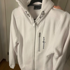 Hoodie - Snygg hoodie från Sail Racing. Ser helt oanvänd ut , därav väldigt bra skick. Använt endast 1 gång.